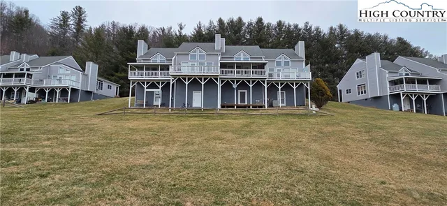 an aerial view of residential houses with outdoor space and trees