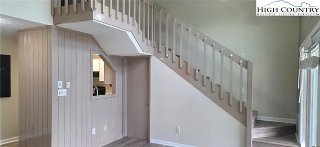 a view of staircase with lots of frames on wall and a window