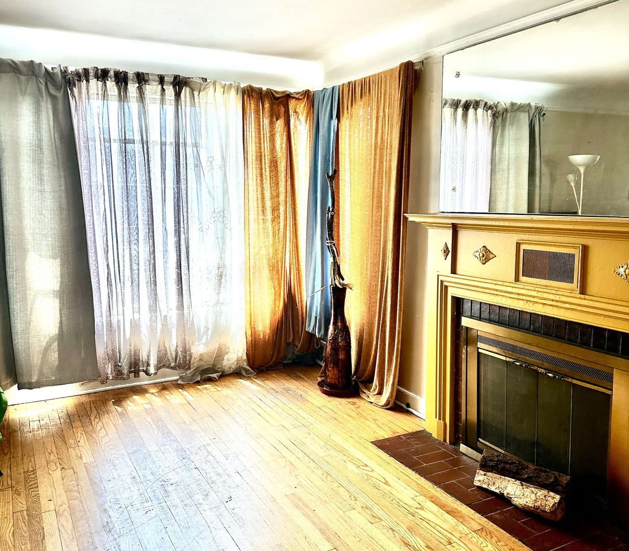 1706 East 83rd Street Chicago, IL 60617 - Photo 3 of 8 a view of a bedroom with wooden floor and a fireplace