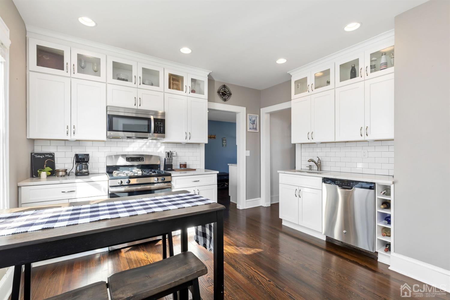 323 Washington Road Sayreville, NJ 08872 - Photo 15 of 40 a kitchen with stainless steel appliances granite countertop a stove top oven a sink dishwasher a refrigerator and white cabinets with wooden floor
