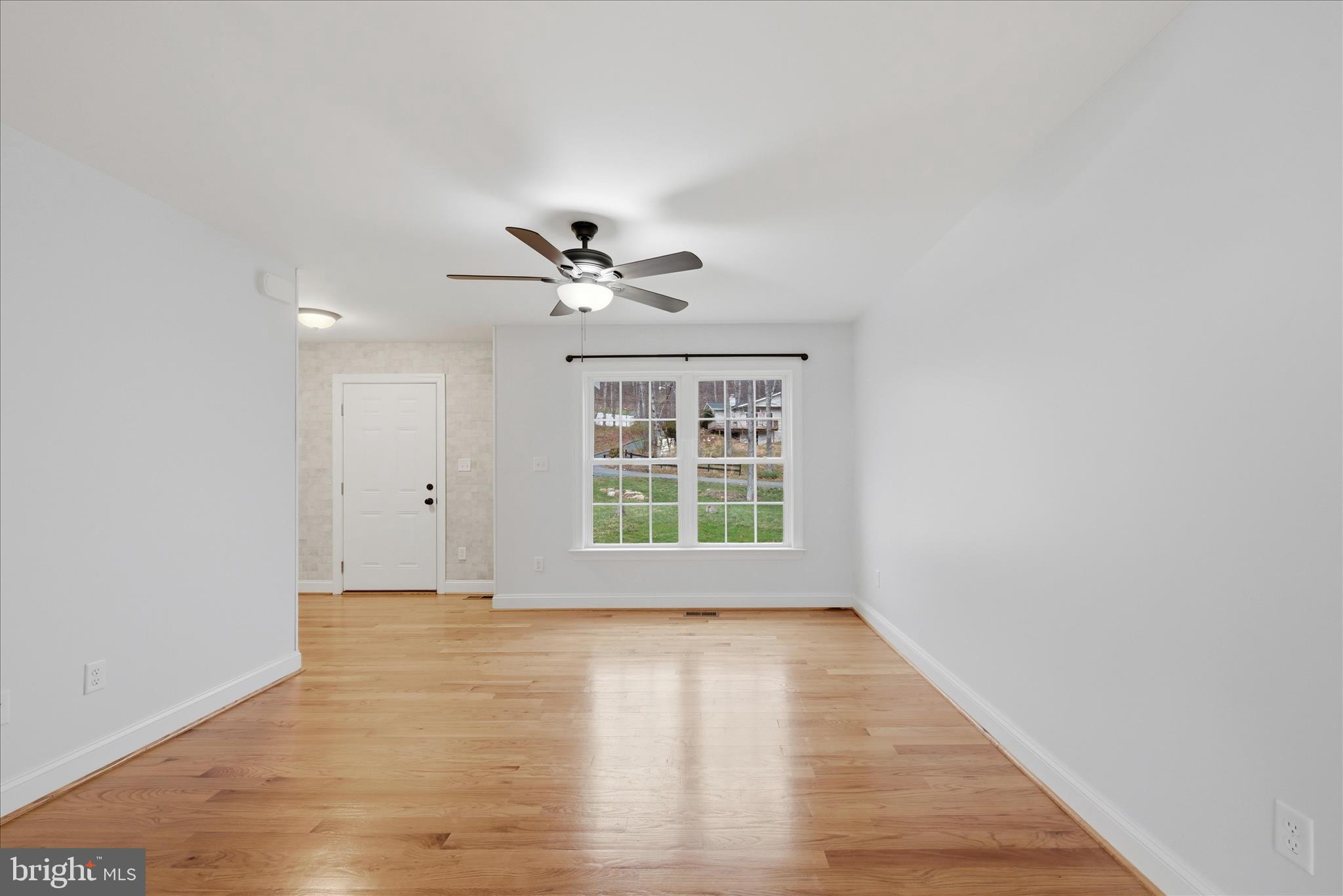 145 Graywolf Trail Winchester, VA 22602 - Photo 16 of 56 a view of an empty room with a window and wooden floor