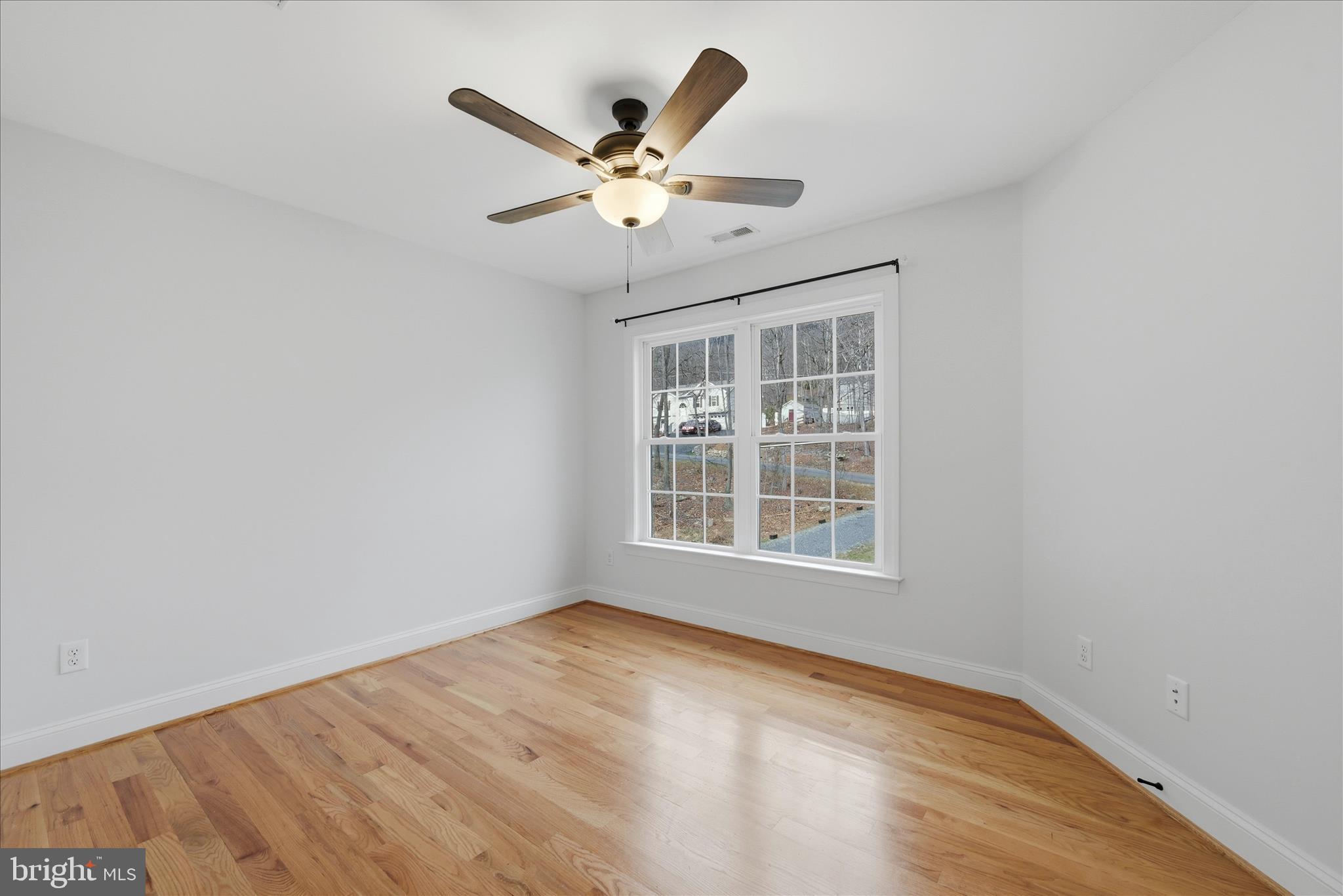 145 Graywolf Trail Winchester, VA 22602 - Photo 28 of 56 an empty room with wooden floor fan and windows