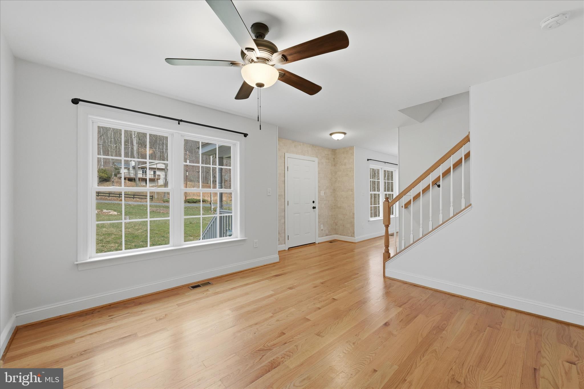 145 Graywolf Trail Winchester, VA 22602 - Photo 7 of 56 a view of an empty room with wooden floor and a window