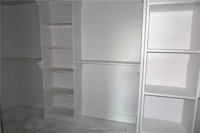 a walk in closet with empty racks