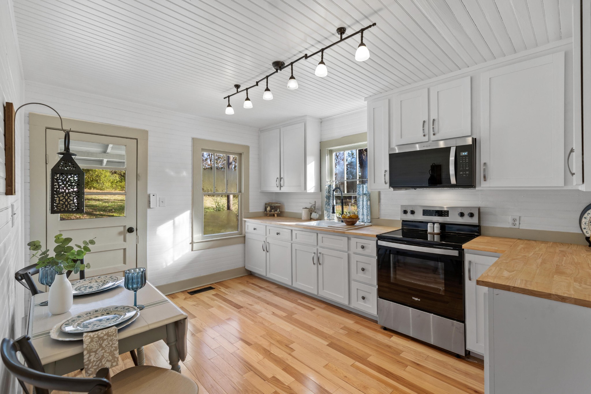 1210 Old Englewood Road Athens, TN 37303 - Photo 11 of 28 a kitchen with stainless steel appliances granite countertop a stove top oven a sink dishwasher a dining table and chairs with wooden floor