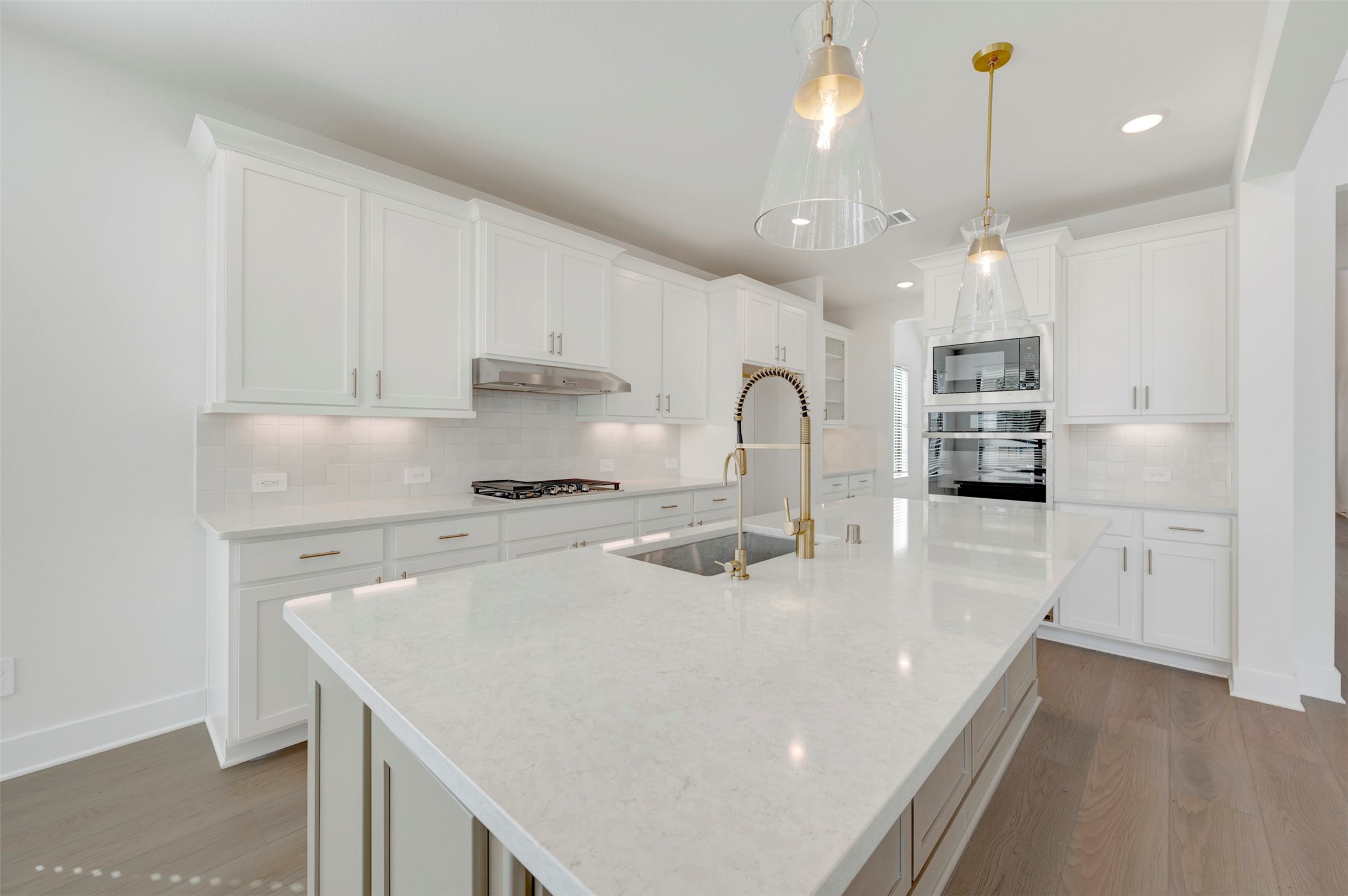 467 6th Street Magnolia, TX 77355 - Photo 32 of 50 a kitchen with kitchen island a stove a sink a center island and cabinets