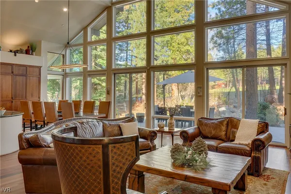 a living room with furniture a large window and wooden floor