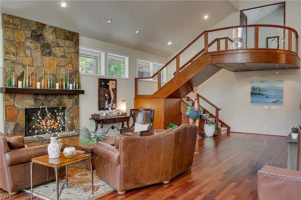 a living room with furniture kitchen view and a wooden floor