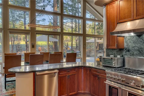 a kitchen with stainless steel appliances granite countertop a stove a sink and a refrigerator