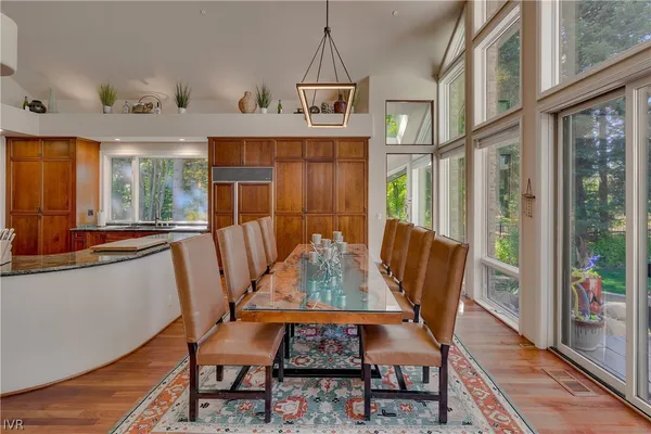 a view of a dining room with furniture a chandelier and wooden floor