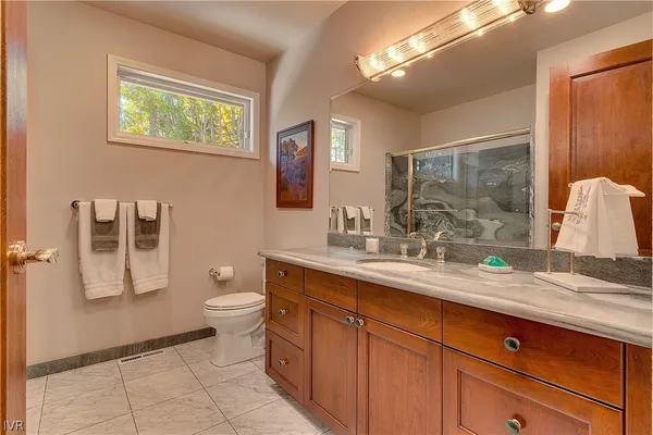 a kitchen with stainless steel appliances granite countertop wooden cabinets a refrigerator and a sink