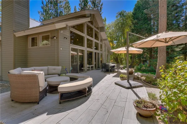 a view of a patio with a dining table and chairs under an umbrella