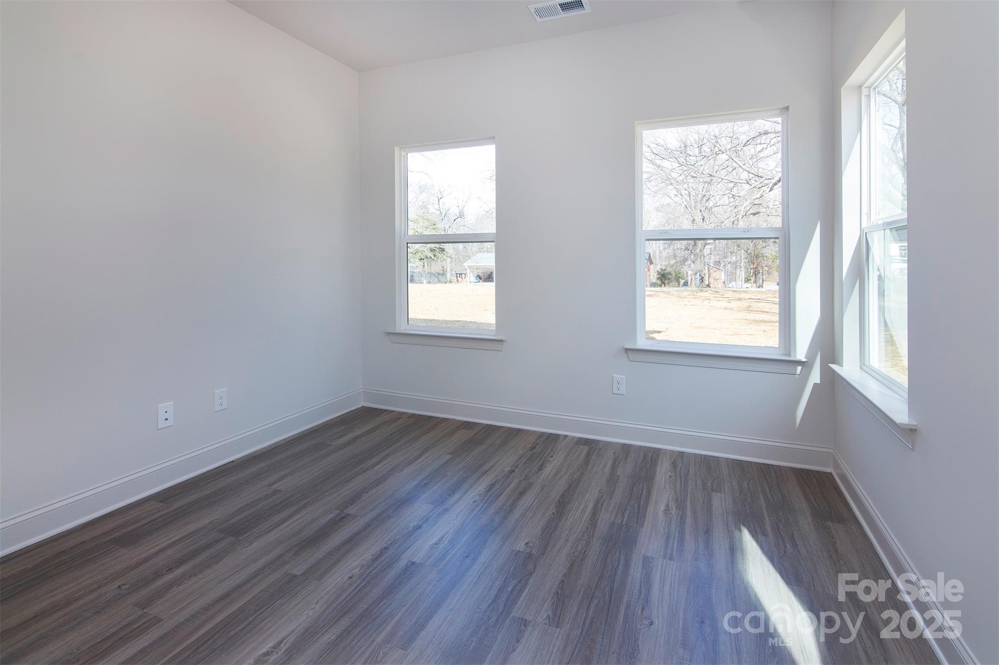 116 Durham Road Stanley, NC 28164 - Photo 11 of 25 an empty room with wooden floor and windows
