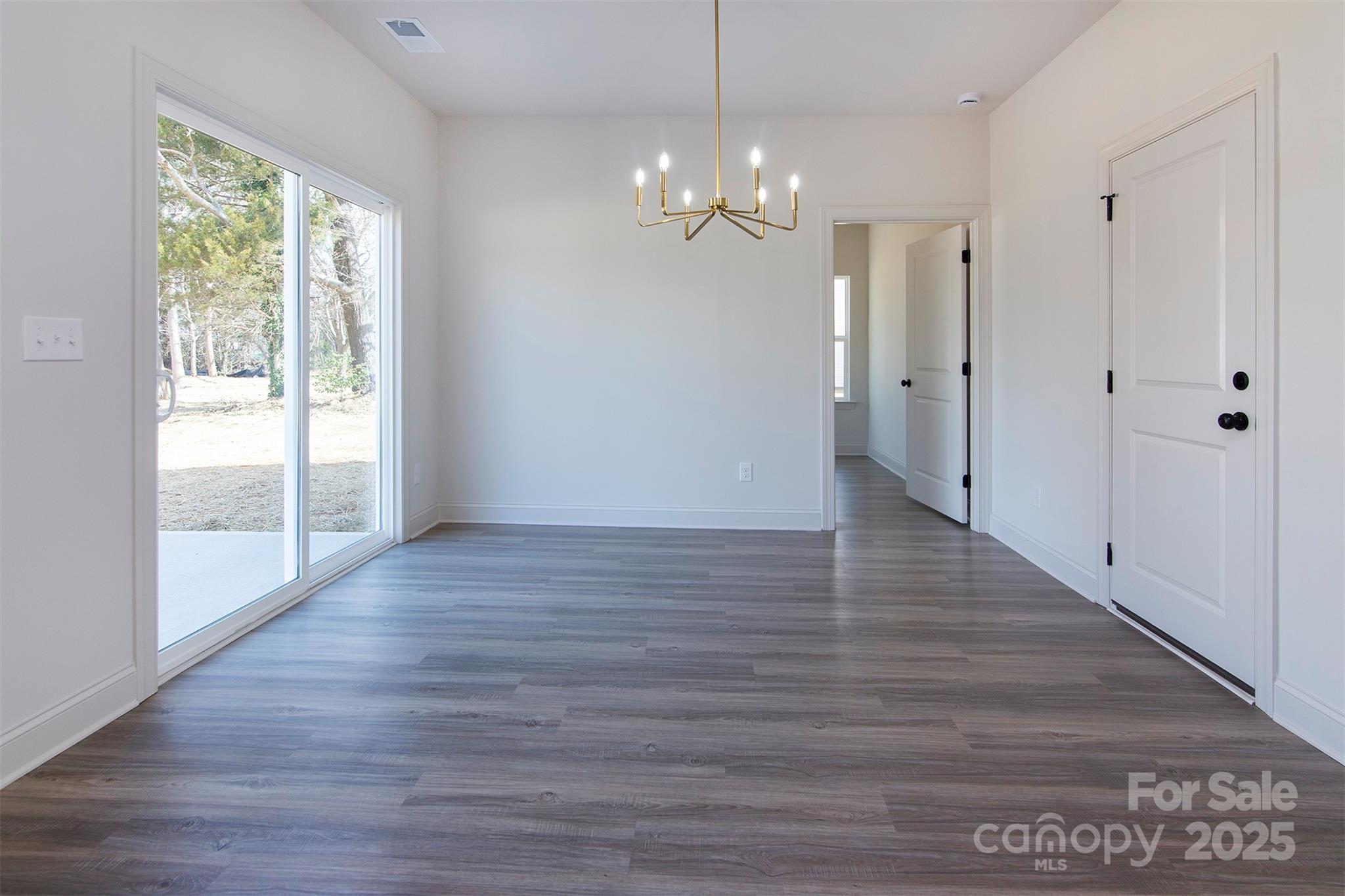 116 Durham Road Stanley, NC 28164 - Photo 10 of 25 a view of an empty room with wooden floor and a window