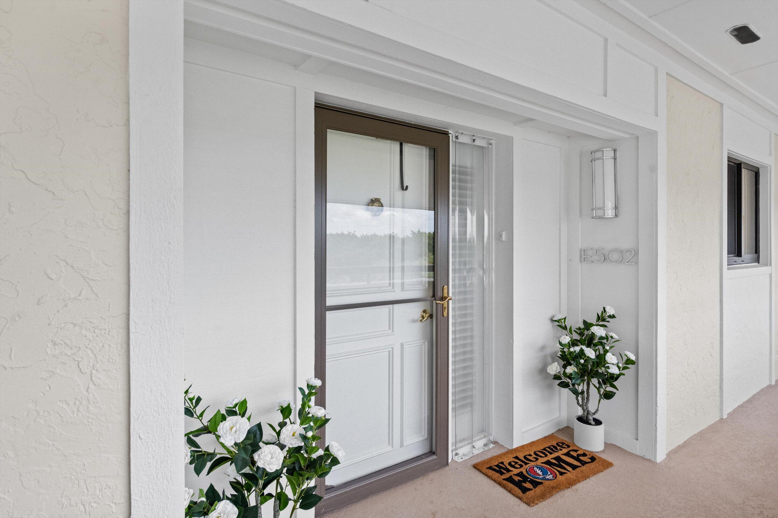 16910 Bay Street, Unit E 502 Jupiter, FL 33477 - Photo 1 of 43 a plant room with wooden floor and a potted plant