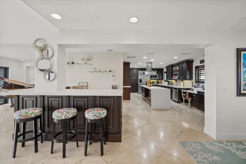 a kitchen with stainless steel appliances kitchen island granite countertop a table and chairs in it