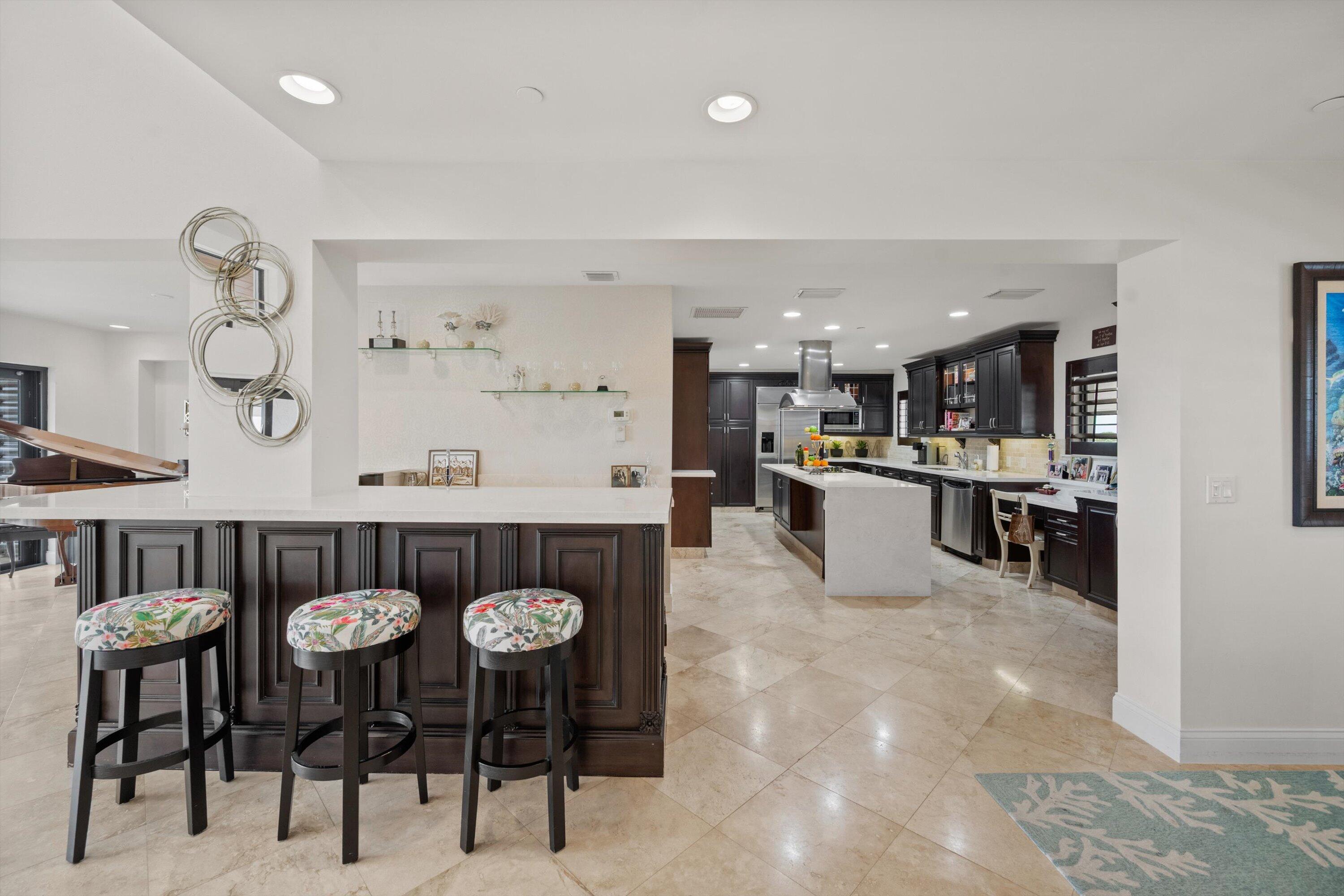 16910 Bay Street, Unit E 502 Jupiter, FL 33477 - Photo 16 of 43 a kitchen with stainless steel appliances kitchen island granite countertop a table and chairs in it