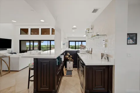 a kitchen with a sink a stove and chairs