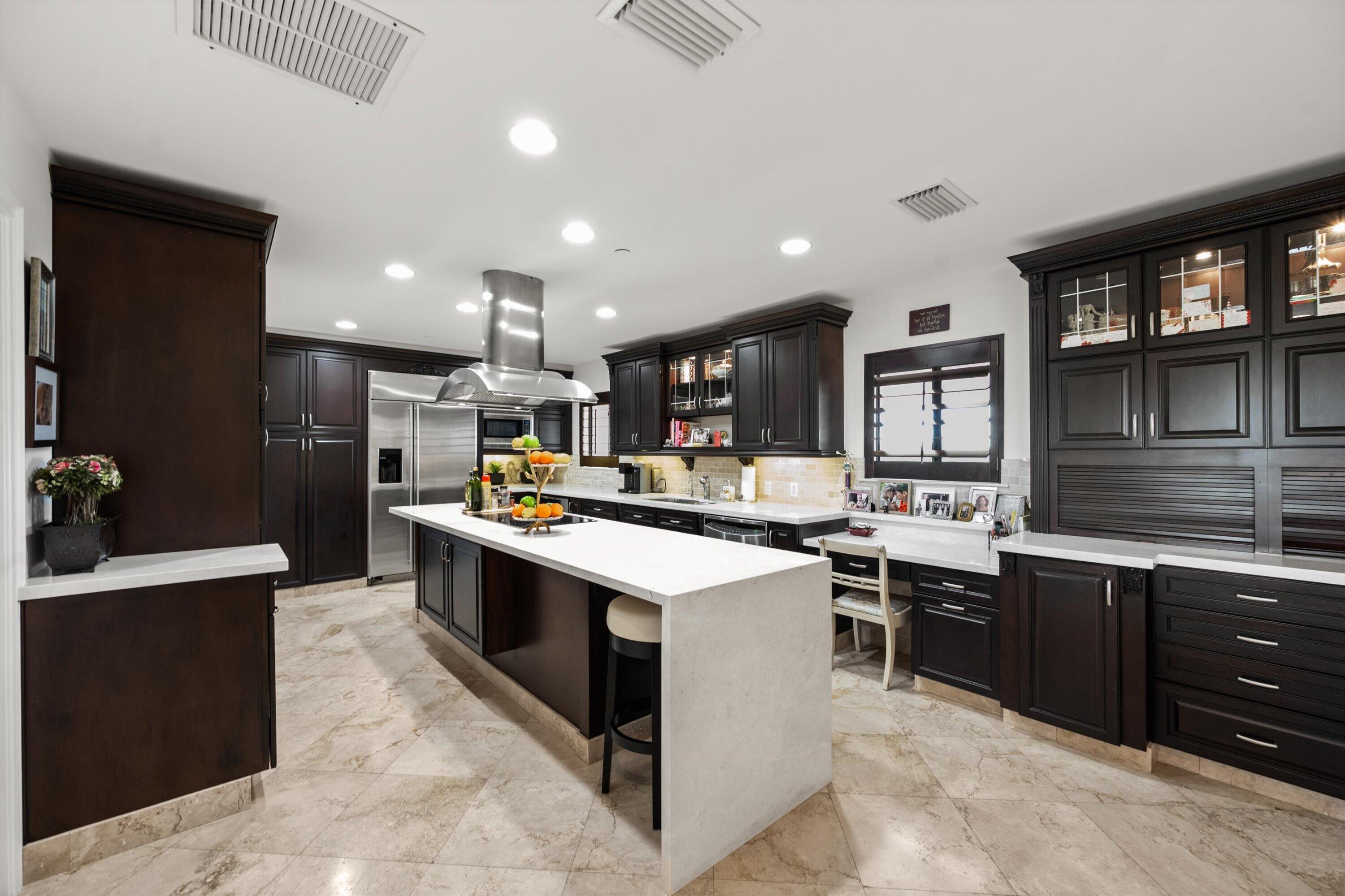 16910 Bay Street, Unit E 502 Jupiter, FL 33477 - Photo 22 of 43 a kitchen with stainless steel appliances kitchen island granite countertop a sink and a refrigerator