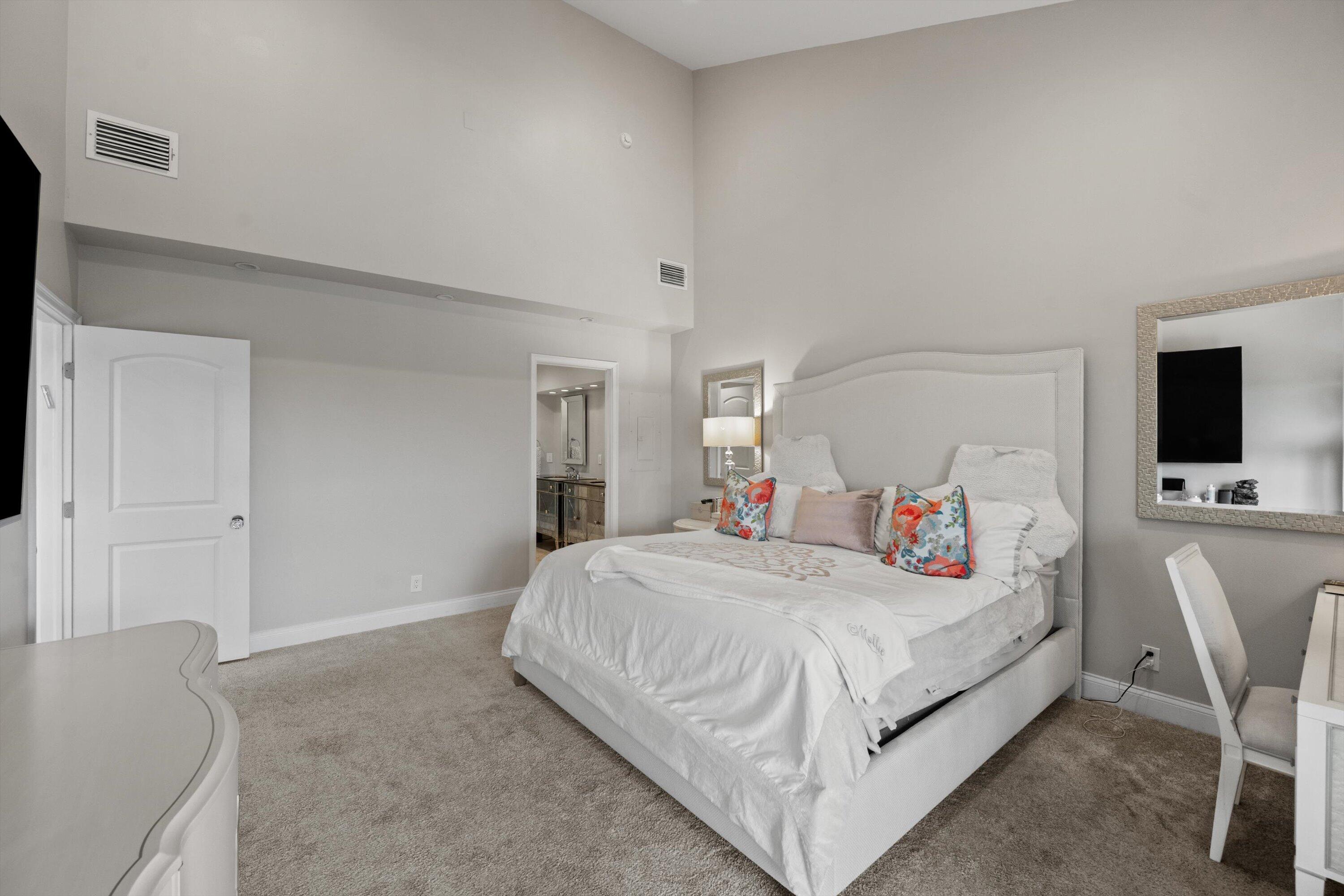 16910 Bay Street, Unit E 502 Jupiter, FL 33477 - Photo 32 of 43 a bedroom with a bed and a flat screen tv