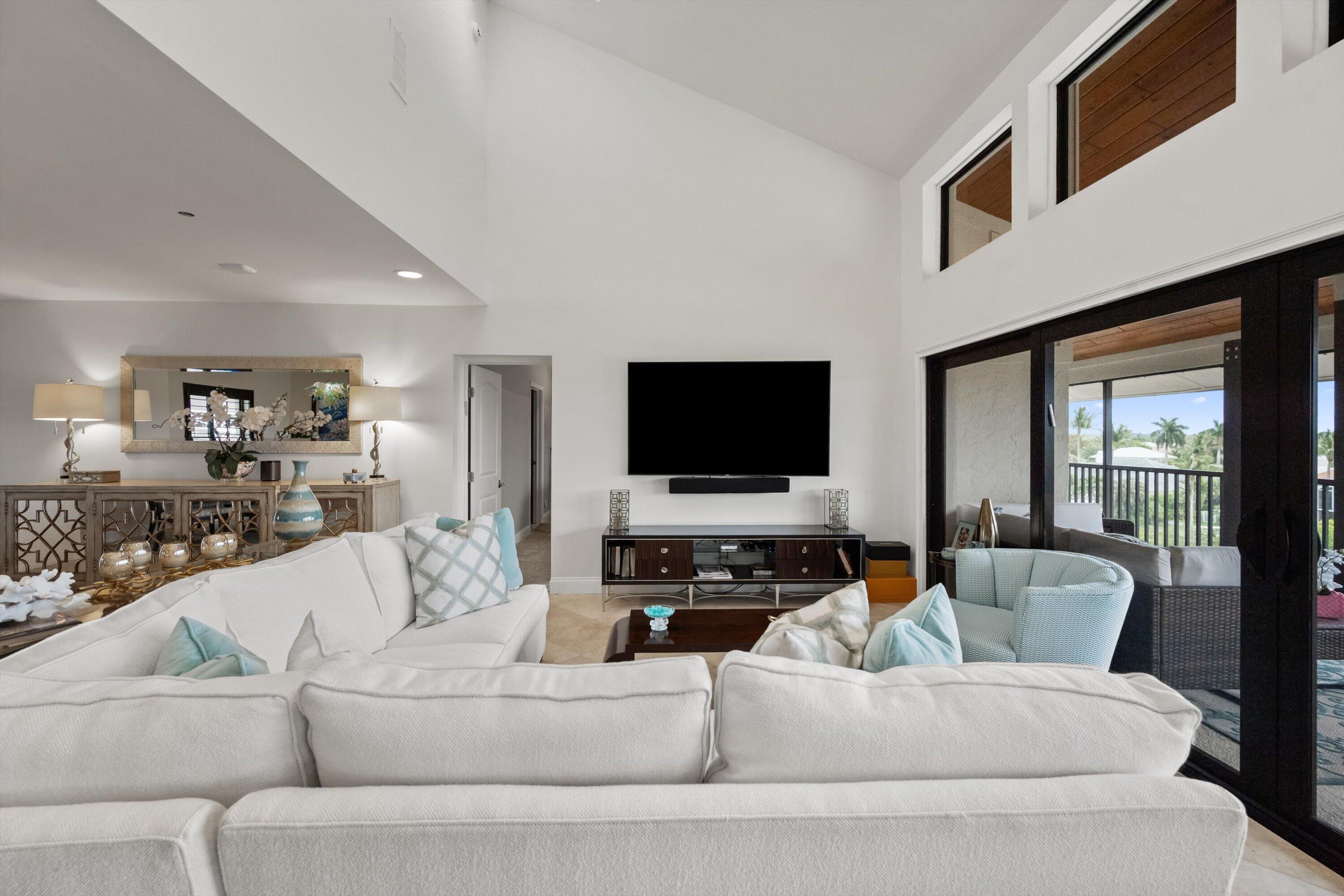 16910 Bay Street, Unit E 502 Jupiter, FL 33477 - Photo 7 of 43 a living room with furniture and a flat screen tv