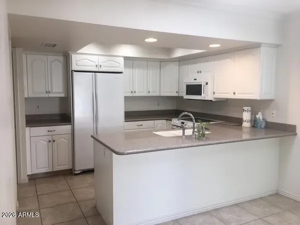 a kitchen with stainless steel appliances granite countertop a sink a refrigerator and a stove