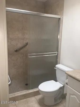 a white toilet sitting next to a shower