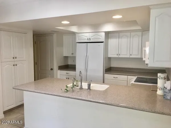 a kitchen with kitchen island a sink and a refrigerator