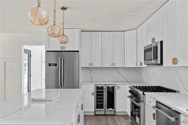 a kitchen with stainless steel appliances granite countertop a stove a microwave and a refrigerator