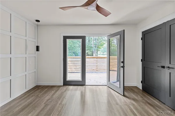 an empty room with wooden floor cabinet and windows