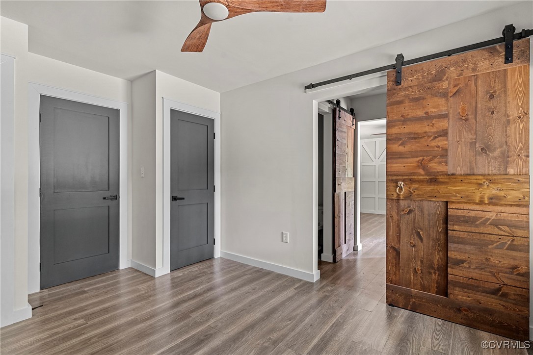 113 Rappa Run Road Topping, VA 23169 - Photo 33 of 49 Empty room featuring a barn door, wood finished fl