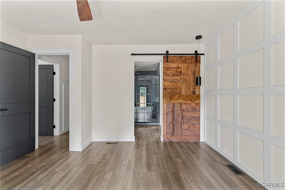 113 Rappa Run Road Topping, VA 23169 - Photo 39 of 49 Spare room featuring a barn door, wood finished fl
