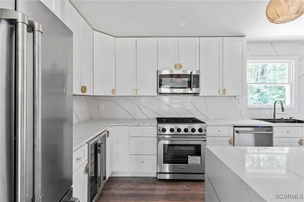 a kitchen with cabinets stainless steel appliances and a window
