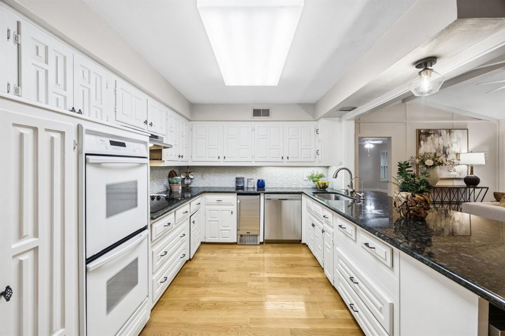 4315 Forest Bend Road Dallas, TX 75244 - Photo 11 of 29 a large kitchen with stainless steel appliances granite countertop a lot of counter space and wooden floors