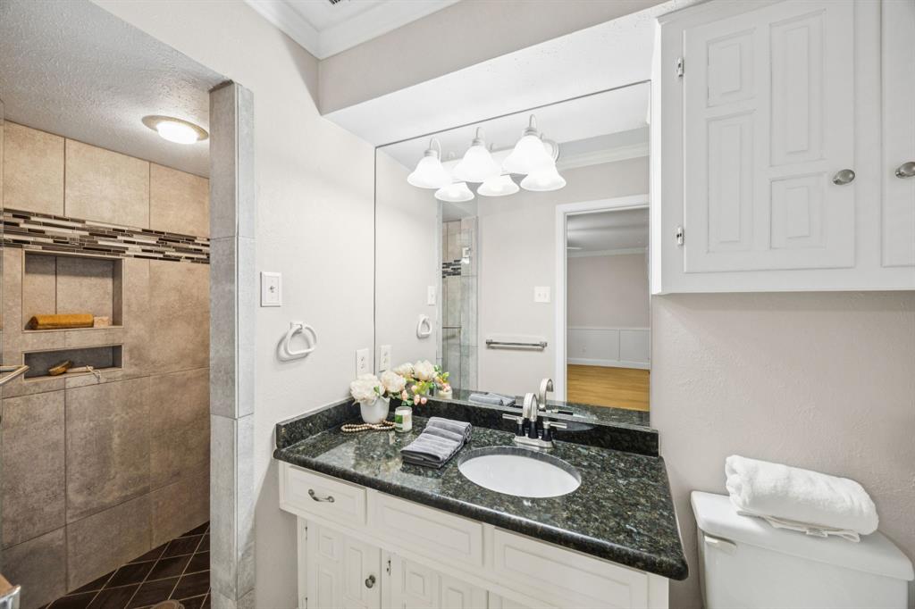 4315 Forest Bend Road Dallas, TX 75244 - Photo 22 of 29 a bathroom with a granite countertop sink a mirror and a shower