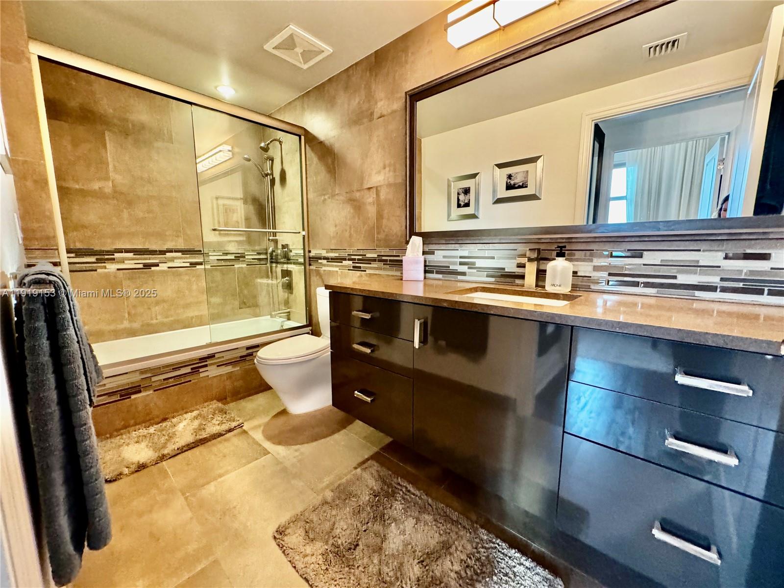 1250 South Miami Avenue, Unit 2403 Miami, FL 33130 - Photo 11 of 28 a bathroom with a sink vanity mirror and toilet