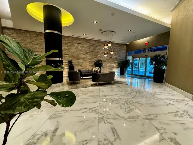 a lobby with a couch and a potted plant