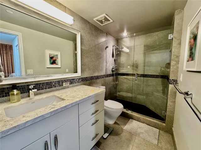 a bathroom with a double vanity sink toilet and shower