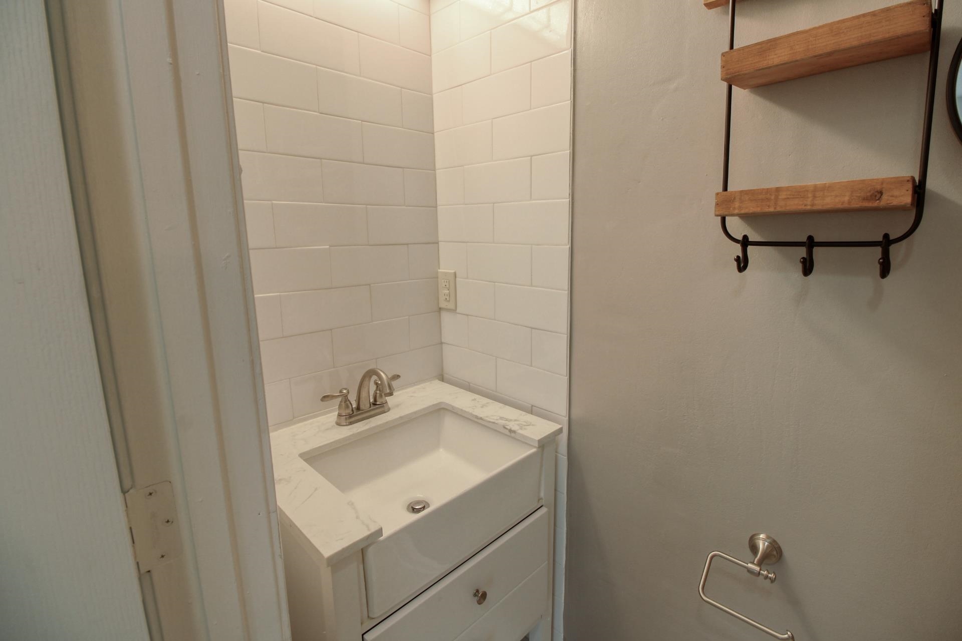 25 Whispering Ridge Cove Oakland, TN 38060 - Photo 11 of 20 Vanity with integrated sink, brushed nickel faucet, and white subway tile surround