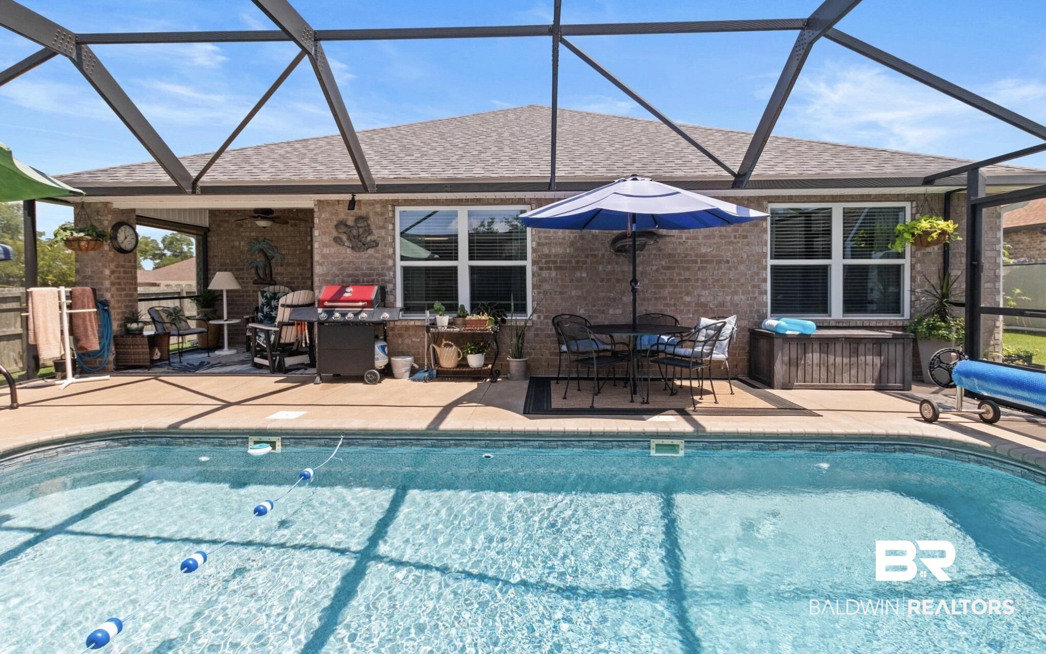 1676 Abbey Loop Foley, AL 36535 - Photo 12 of 31 Screened-in pool area featuring a rectangular swimming pool, a covered patio, and a brick exterior