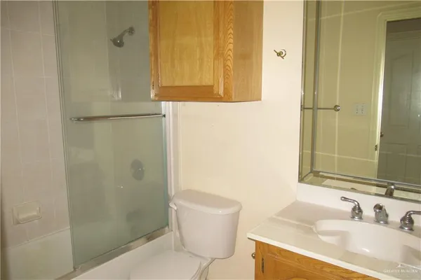 a bathroom with a granite countertop sink a toilet and shower