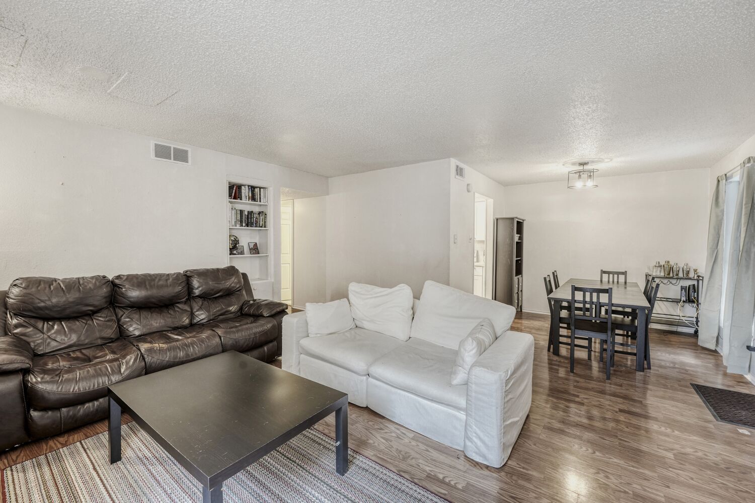 2401 Leon Street, Unit 100 Austin, TX 78705 - Photo 7 of 24 a living room with furniture and a dining table with wooden floor