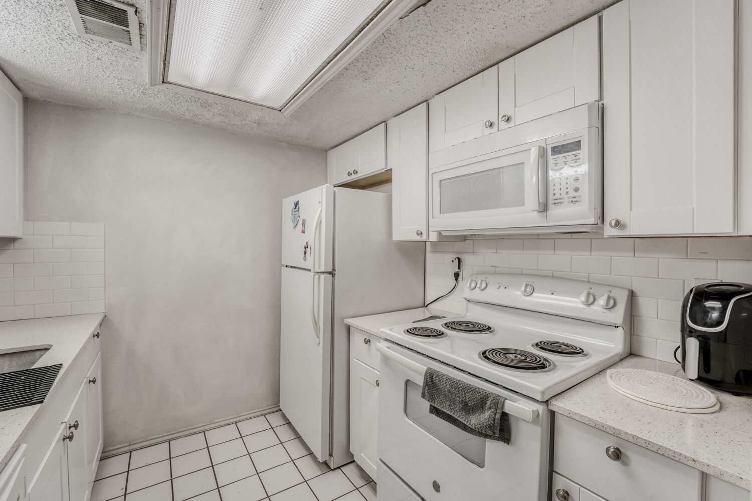 2401 Leon Street, Unit 100 Austin, TX 78705 - Photo 10 of 24 a kitchen with white cabinets and white appliances