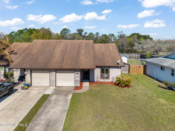 an aerial view of a house with a yard and potted plants