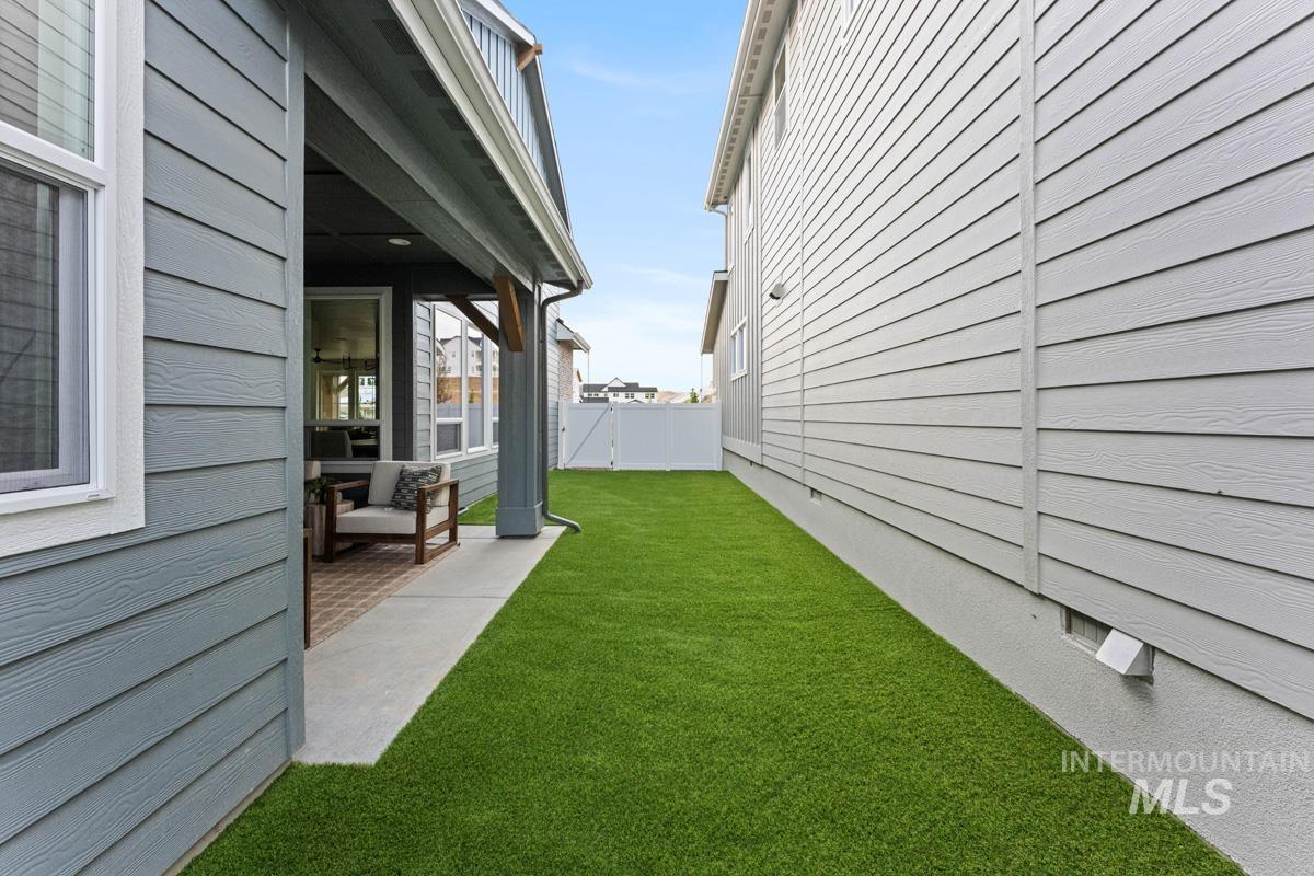 13338 North Spring Creek Way Boise, ID 83714 - Photo 33 of 46 Side yard featuring artificial turf and a covered patio with a textured concrete surface