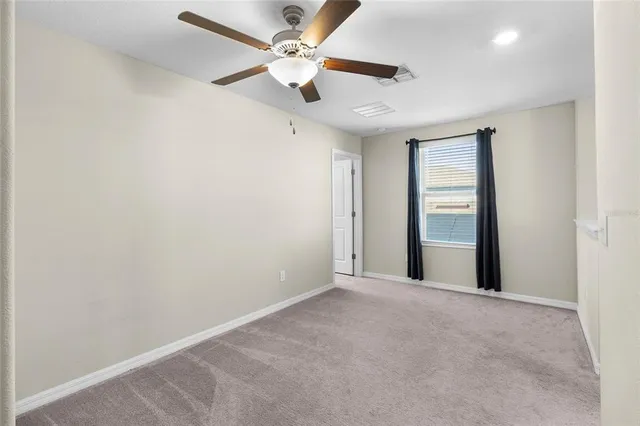 an empty room with chandelier fan