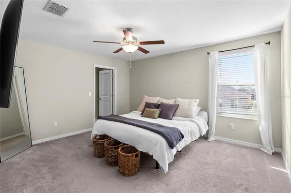 a spacious bedroom with a bed and a window