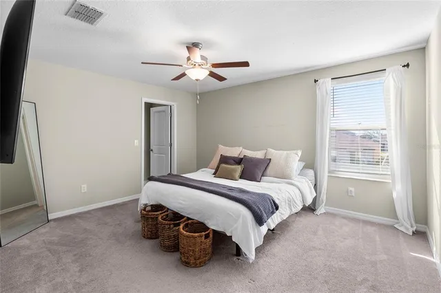 a spacious bedroom with a bed and a window