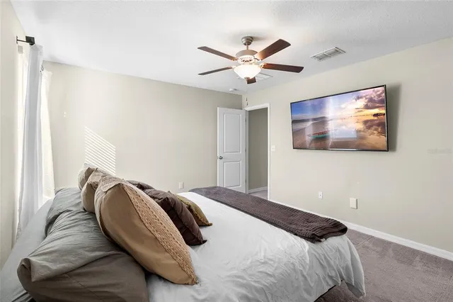a bedroom with a bed and painting on the wall