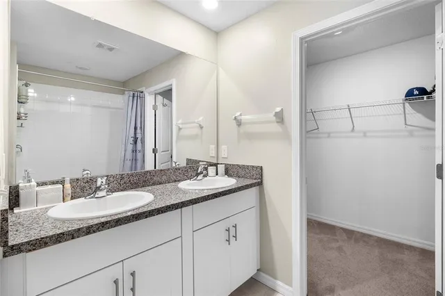 a bathroom with a granite countertop sink and a mirror